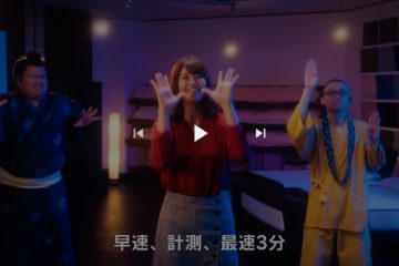 ASLEEP『カラダハカリズム』新WEB動画 /振付。YouTubeより静止画。センターに稲村亜美さん。左に力士役、右にお坊さん役の役者さん。踊りのシーン。