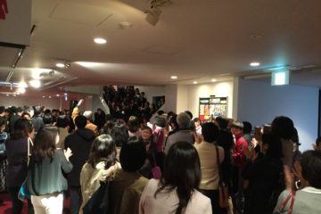 終演後客出しのロビー大盛り上がり。歌い続ける学生。